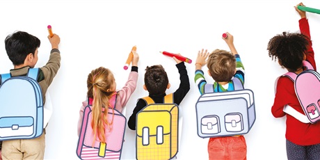 Powiększ grafikę: Dzieci stoją przodem do białej ściany z kolorowymi ołówkami w rękach. Wykonują ruch, jakby chciały coś napisać lub narysować. Na plecach mają założóne kolorowe, rysunkowe plecaki. 